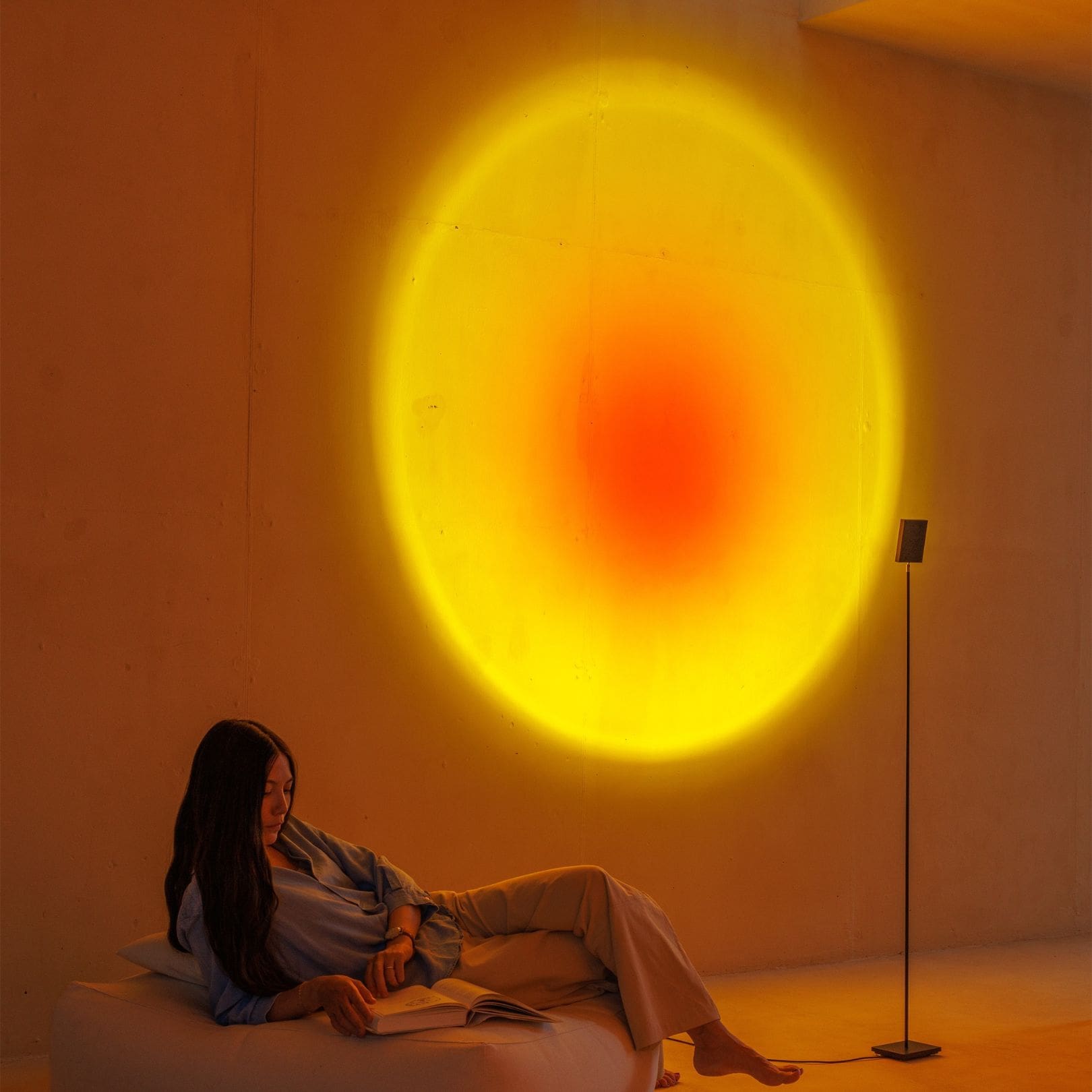 Warm light art installation on wall casting a vibrant gradient circle, creating a serene ambiance